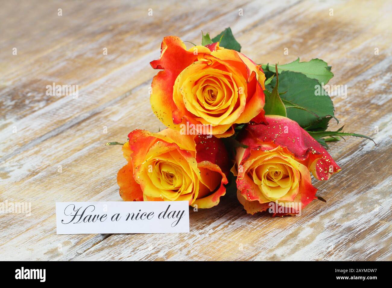 Haben Sie eine schöne Tageskarte mit drei orangefarbenen Rosen, die mit Glitter auf Holzoberfläche bedeckt sind Stockfoto