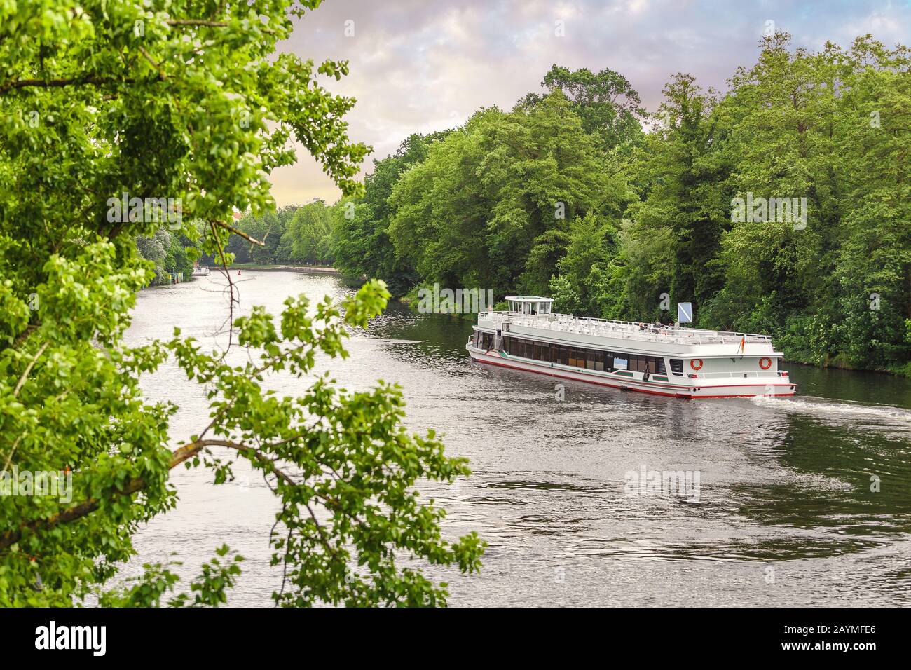 White Vacation Fährschiff auf der Fahrt auf dem Fluss mit schönem Wald in Europa Stockfoto
