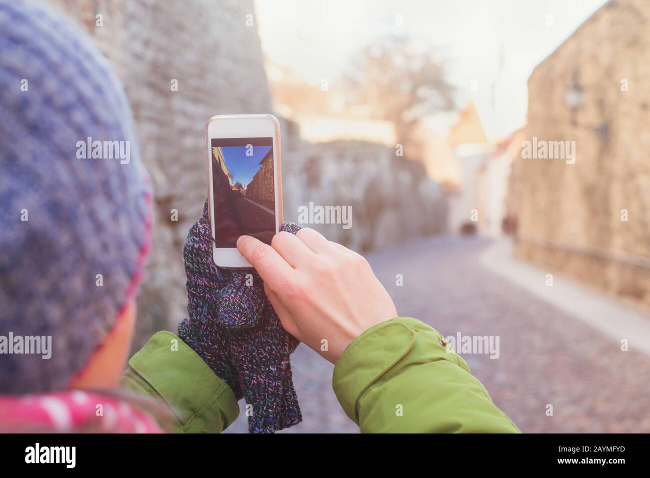 Frau, die mit ihrem Smartphone fotografieren kann, während sie in der Hauptstadt Estlands in Tallinn unterwegs ist Stockfoto