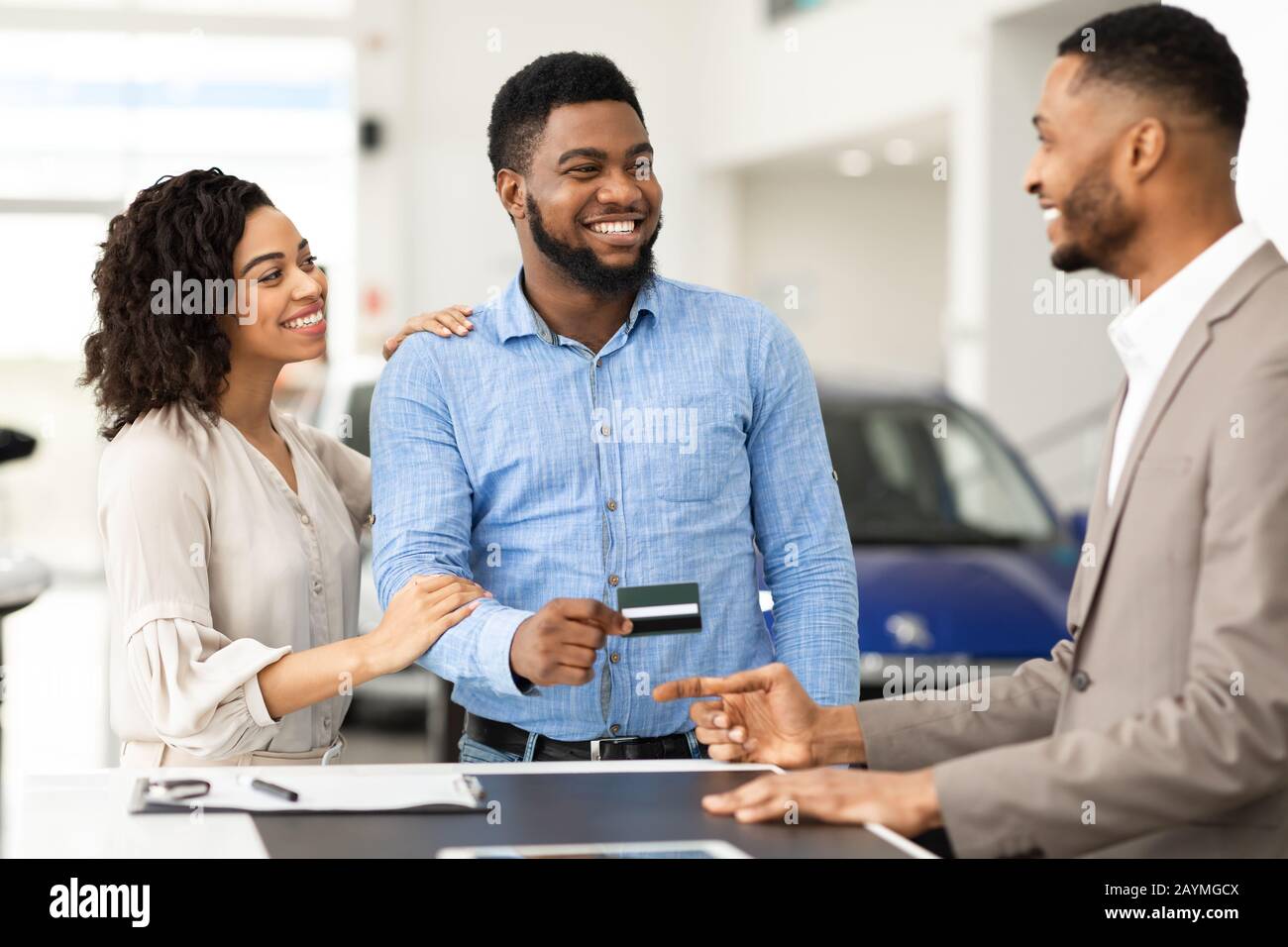 Paare Kaufen Auto Geben Verkäufer-Kreditkarte Im Händlerbüro Stockfoto