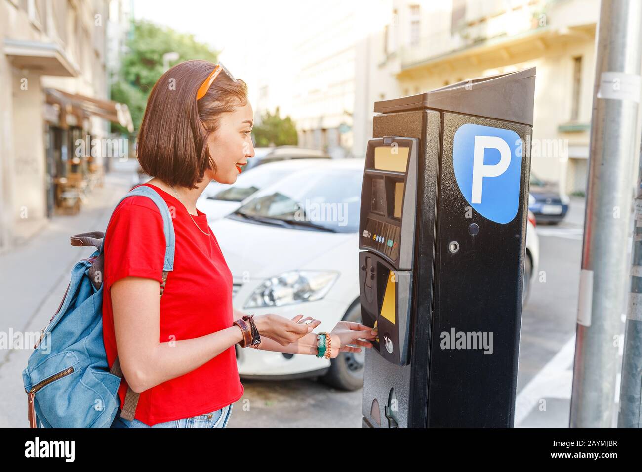 Weibliche Fahrer zahlt für die Parkuhr mit einem Paybyphone Handy
