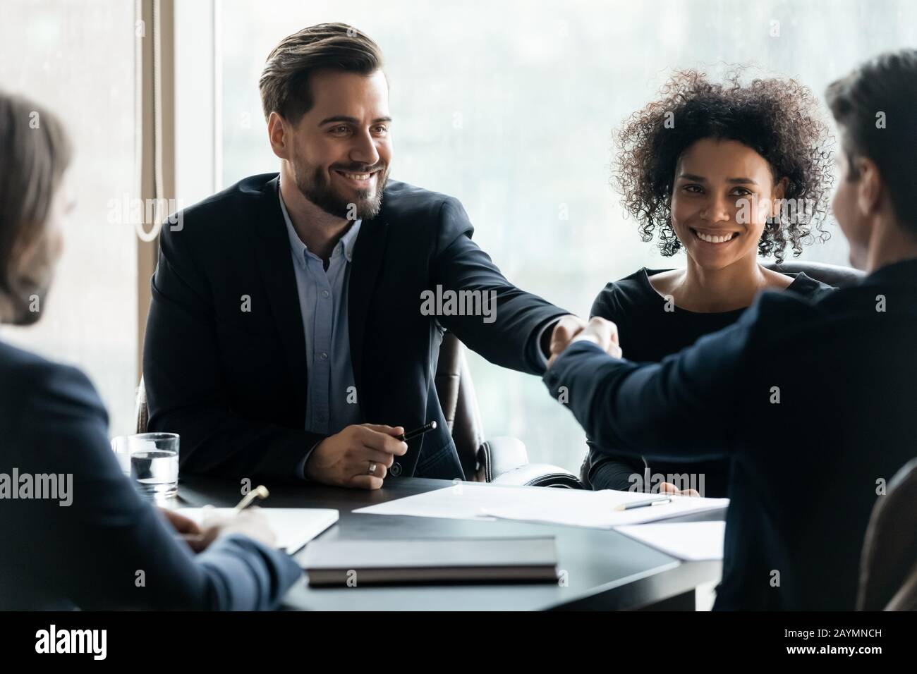 Glücklicher erfolgreicher Geschäftsmann im Anzug, der die Hand des Geschäftspartners schüttelt. Stockfoto