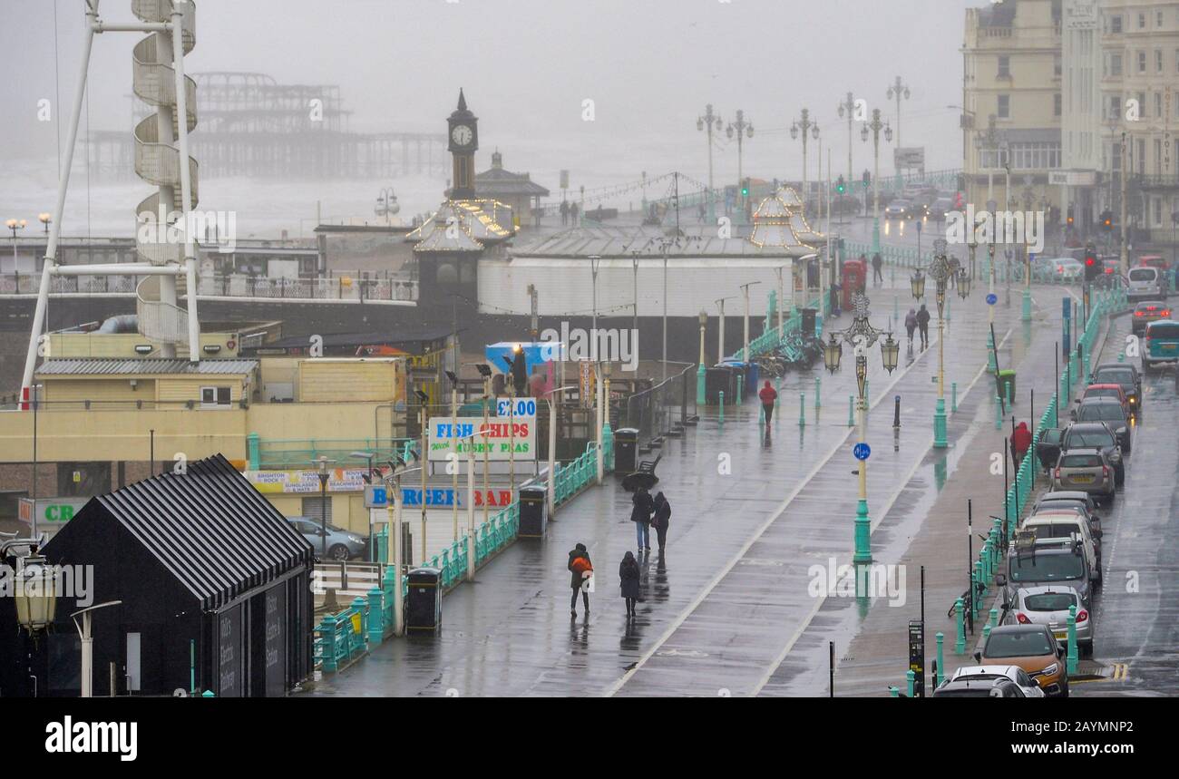 Brighton UK 16. Februar 2020 - EIN paar mutige Besucher trotzen dem Wetter an der Küste von Brighton, da Sturm Dennis heute starken Regen und starken Wind aus der Galeere in die meisten Gegenden Großbritanniens bringt: Credit Simon Dack / Alamy Live News Stockfoto