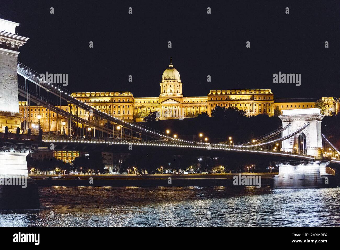 Blick auf die Budapester Nationalgalerie und die Szechenyi-Kettenbrücke nachts vom Fluss Donau Stockfoto