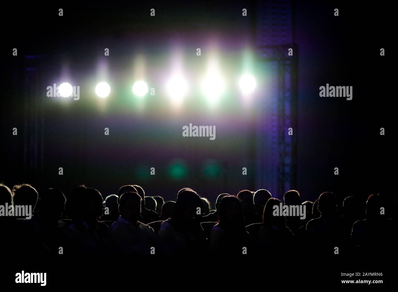 Silhouetten von Menschen unter hellen Hintergrundlichtern Stockfoto