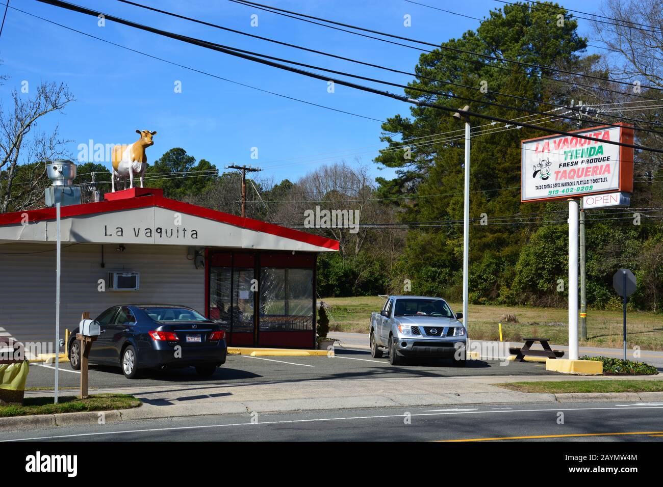 Eine lebensgroße Kuh sitzt auf La Vaquita Taqueria in Durham North Carolina. Stockfoto