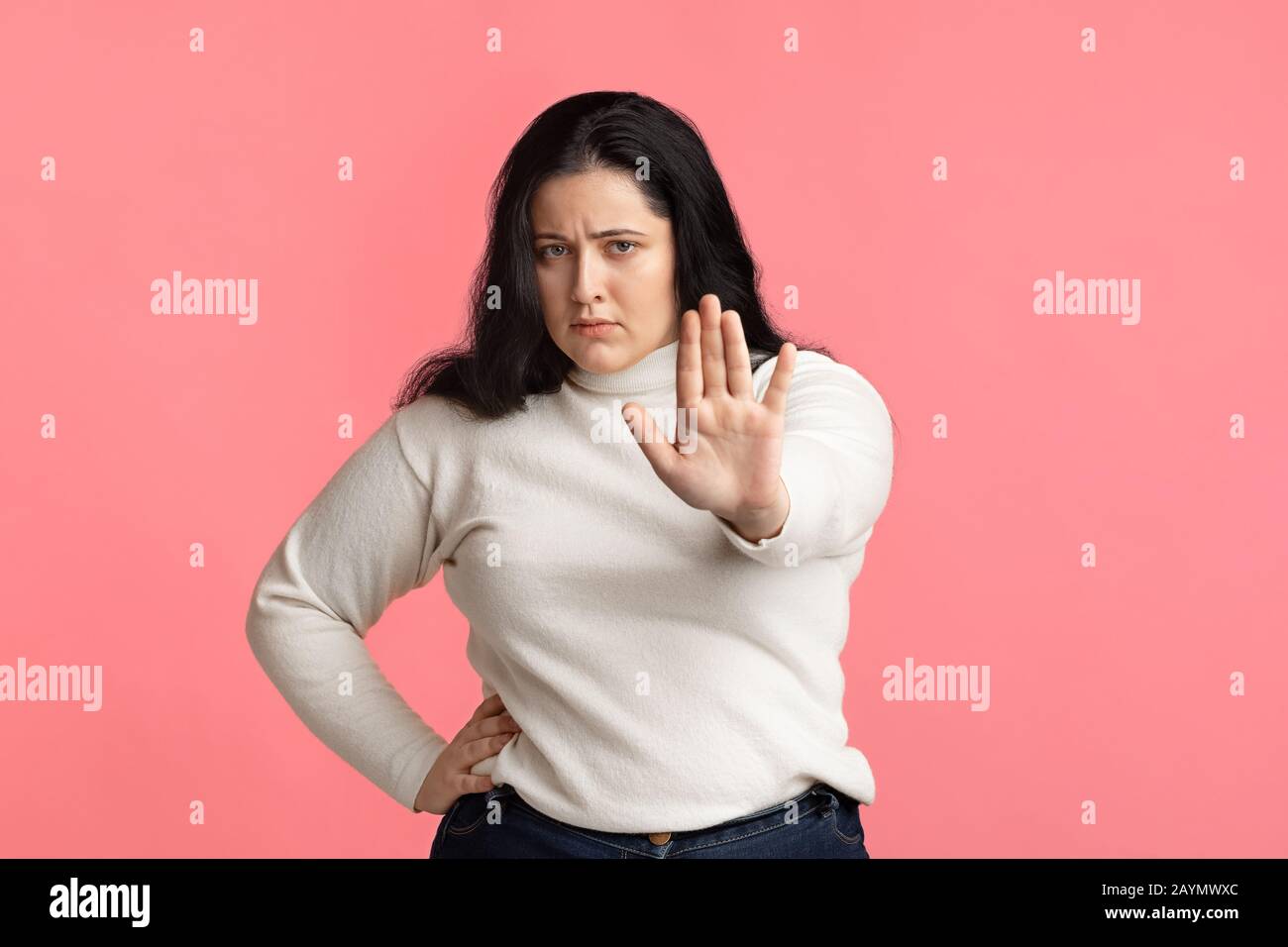 Schweres übergewichtiges Mädchen mit Stopp-Geste, mit ausgestreckter Hand stehend Stockfoto