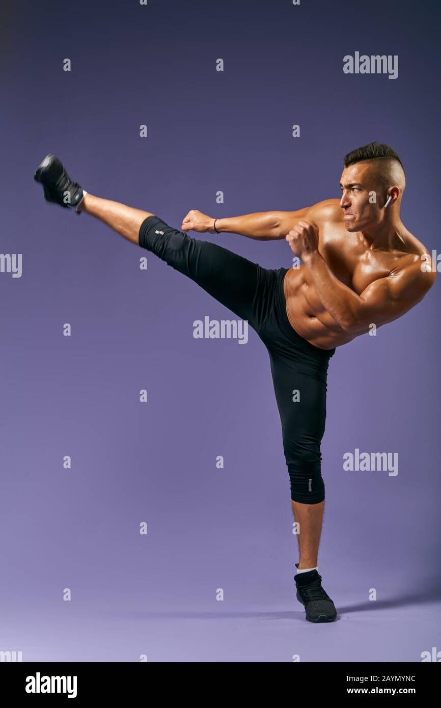 Wütende Kämpfer, die ein Bein hochziehen und bereit sind, den Gegner zu treten. Boxen, Kickboxen, Kampfsport, Sport, Kraft und Kraft Konzept.Kampfkunst, Hobby, Interesse, Stockfoto