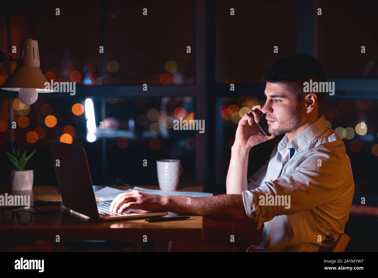 Office Manager Ruft Den Kunden Spät Am Abend Am Arbeitsplatz An Stockfoto