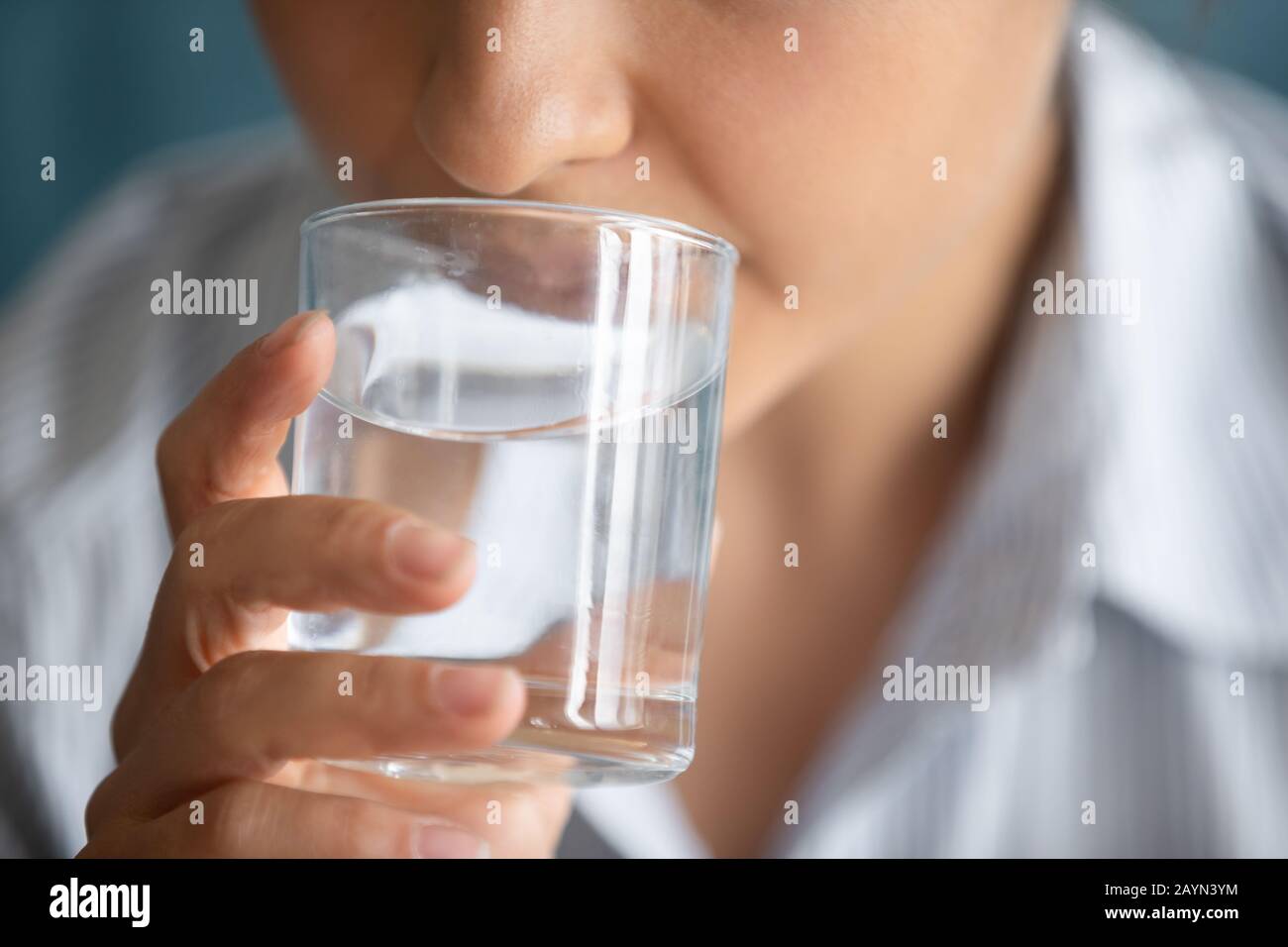Junge Frau trinkt reines Mineralwasser aus Glas Stockfoto