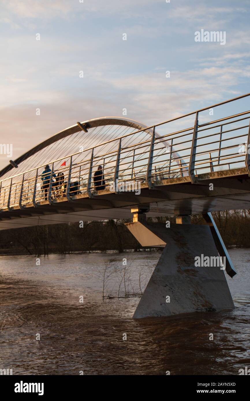 Wetter in Großbritannien. Pendler gehen über die Millennium Bridge am überfluteten Fluss Ouse in York vorbei. Stockfoto