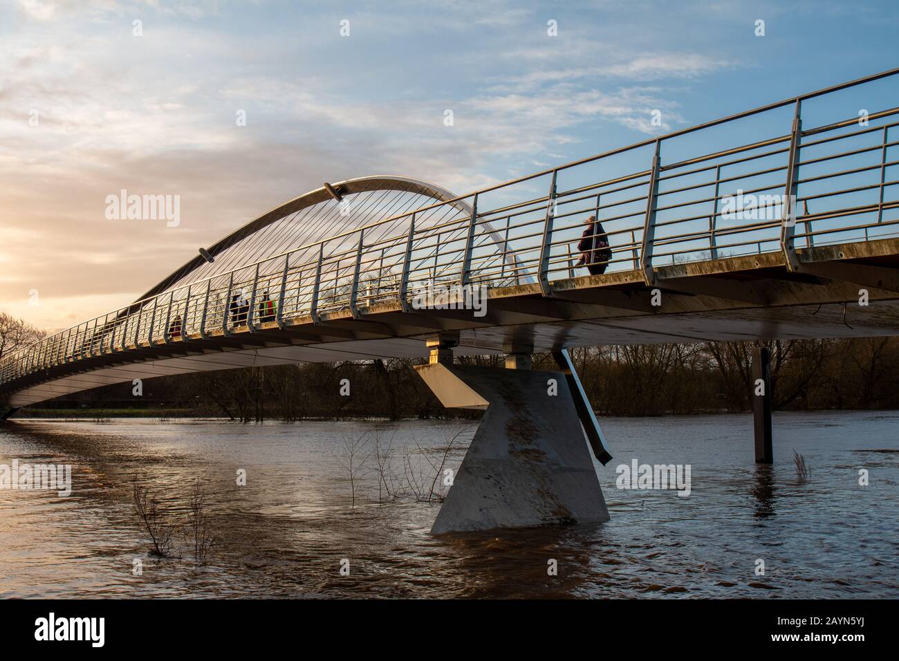 Wetter in Großbritannien. Pendler gehen über die Millennium Bridge am überfluteten Fluss Ouse in York vorbei. Stockfoto