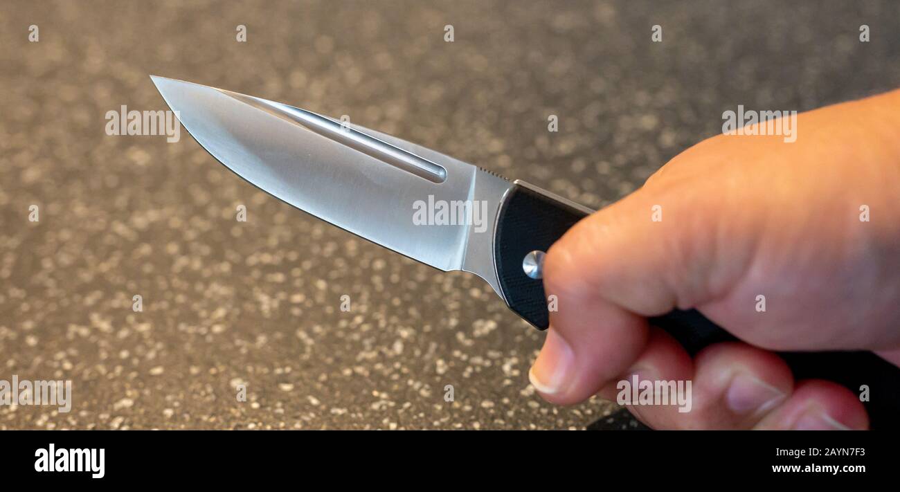 Symbole, Symbolbild, Eine Faust haelt ein Messer in der Hand. Stockfoto