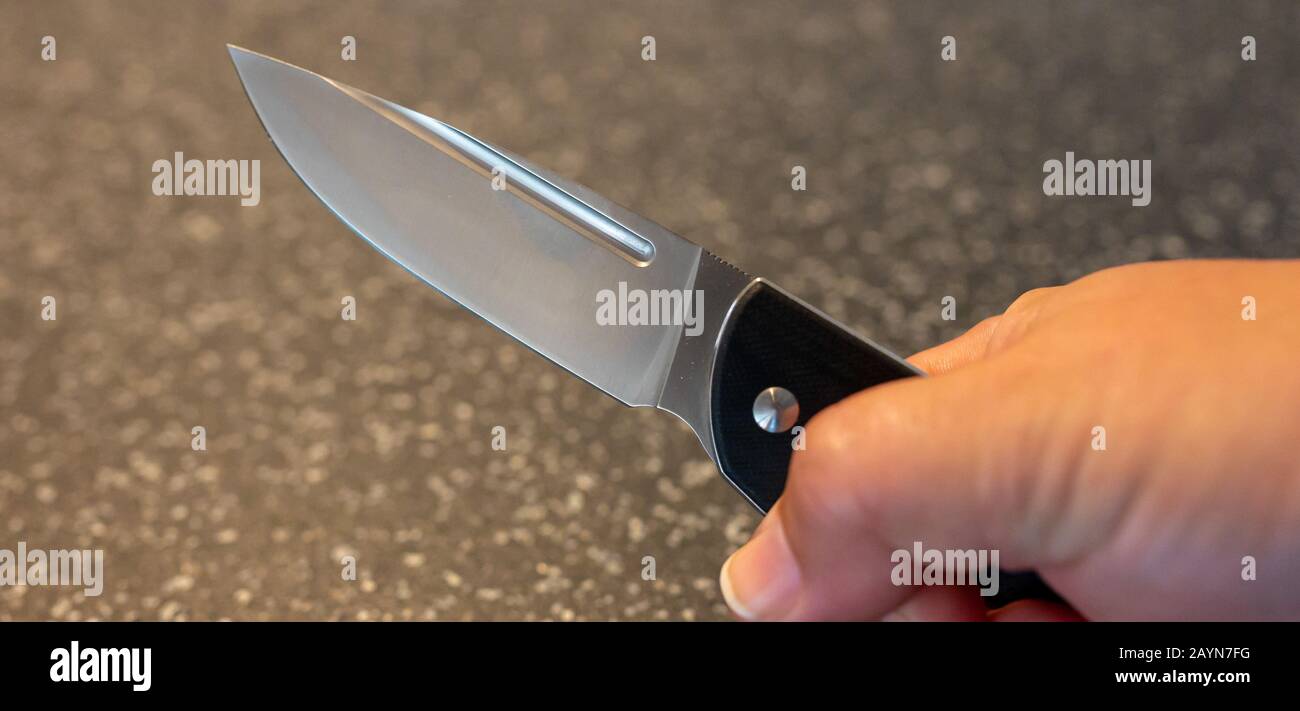Symbole, Symbolbild, Eine Faust haelt ein Messer in der Hand. Stockfoto