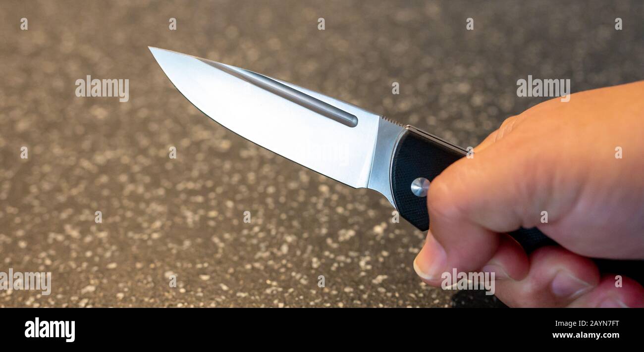 Symbole, Symbolbild, Eine Faust haelt ein Messer in der Hand. Stockfoto