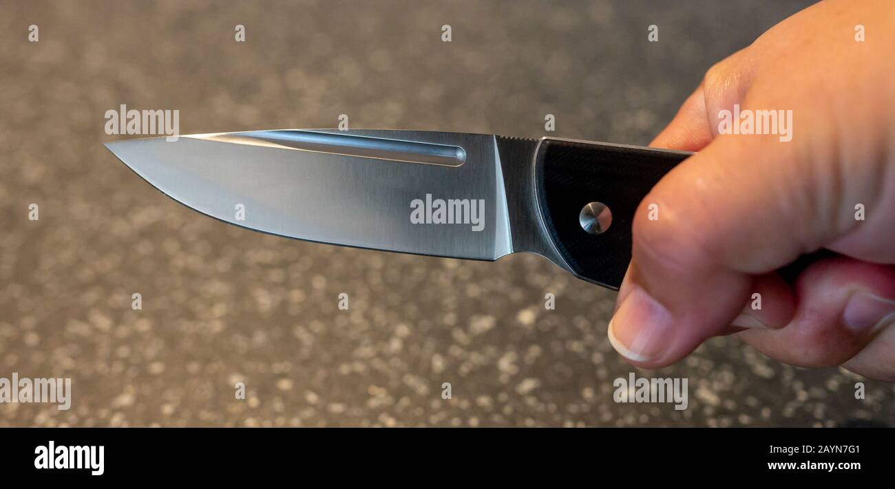 Symbole, Symbolbild, Eine Faust haelt ein Messer in der Hand. Stockfoto