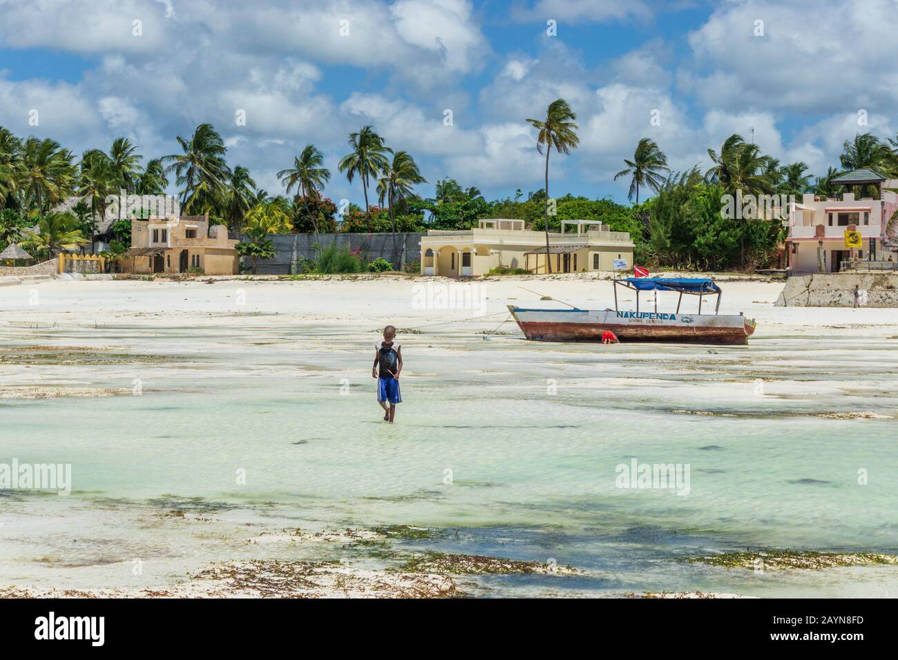 Jambiani, INSEL SANSIBAR, TANSANIA - 25. AUGUST 2019: Bei Ebbe läuft ein Kind am Strand Stockfoto