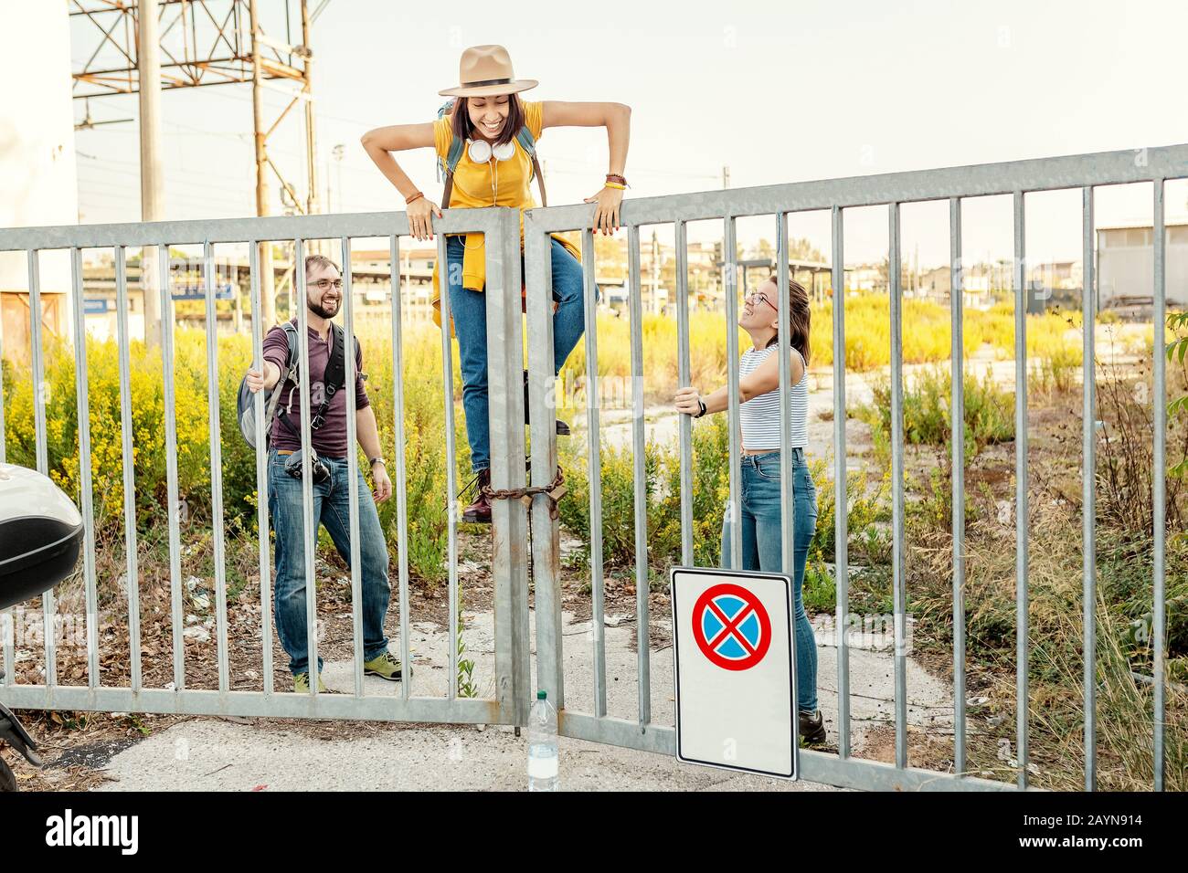 Eine Gruppe von Freunden, die Spaß haben und über Zaun klettern, brechen das Regelkonzept Stockfoto