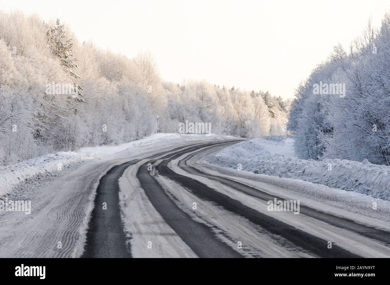 Schöne Straße durch den Winterwald. Frostige Reise Stockfoto