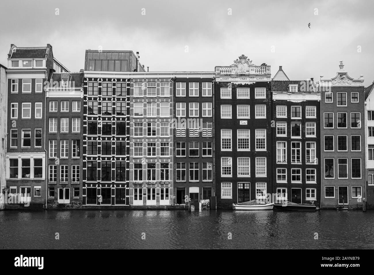 Ein Schwarz-Weiß-Foto von traditionellen holländischen Gebäuden am Fluss in Amsterdam Stockfoto