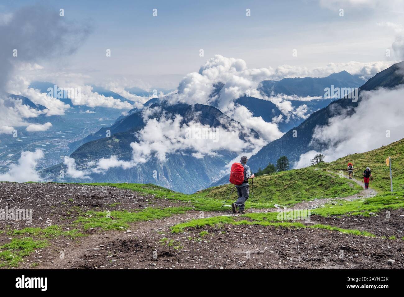Wanderer auf der Tour du Mont-Blanc-Wanderung in der Schweiz mit wolkenbedeckten Bergen im Hintergrund Stockfoto Wanderer auf der Tour du Mont-Blanc-Wanderung in der Schweiz mit wolkenbedeckten Bergen im Hintergrund Stockfoto