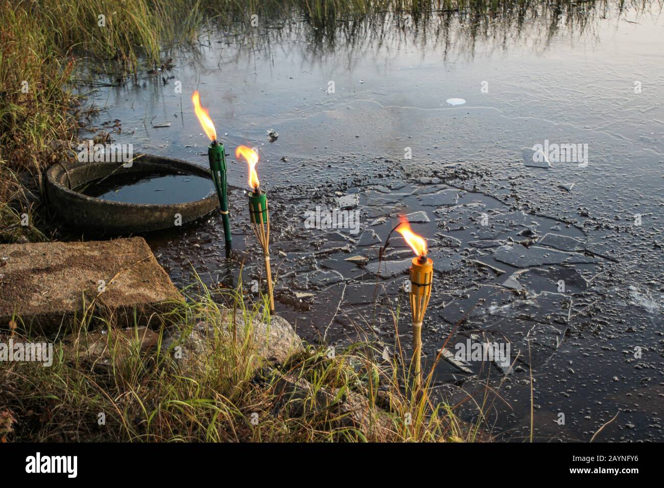 Brennende Fackeln am gefrorenen See Stockfoto