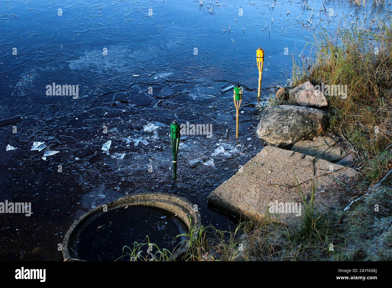 Verbrannte Fackeln am gefrorenen See Stockfoto