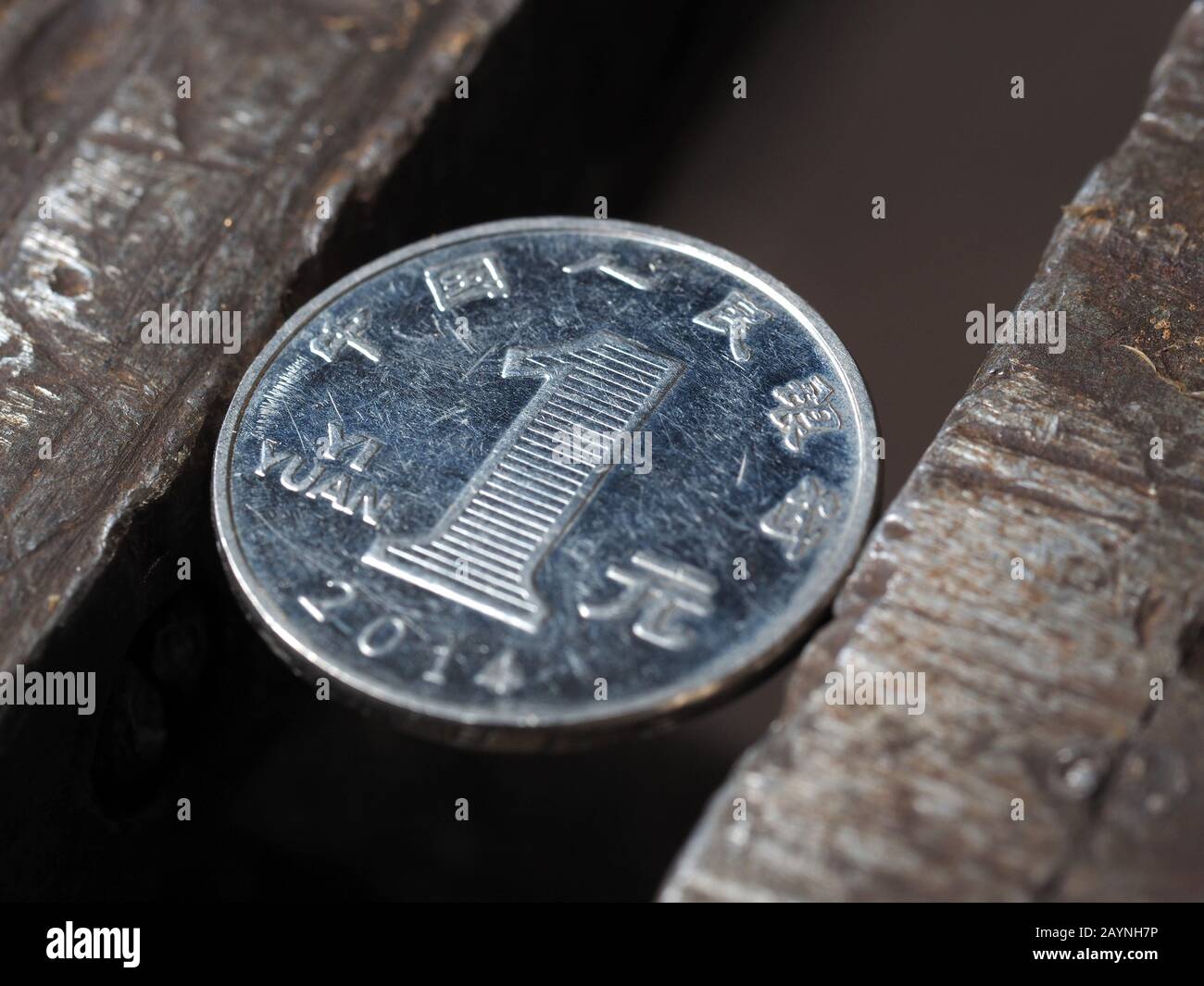 Draufsicht über die eine Yuan-Münze in einem Metall-Schraubstock. Währung und Wirtschaft unter dem Ansturm, das Konzept der finanziellen Probleme und der Krise Stockfoto