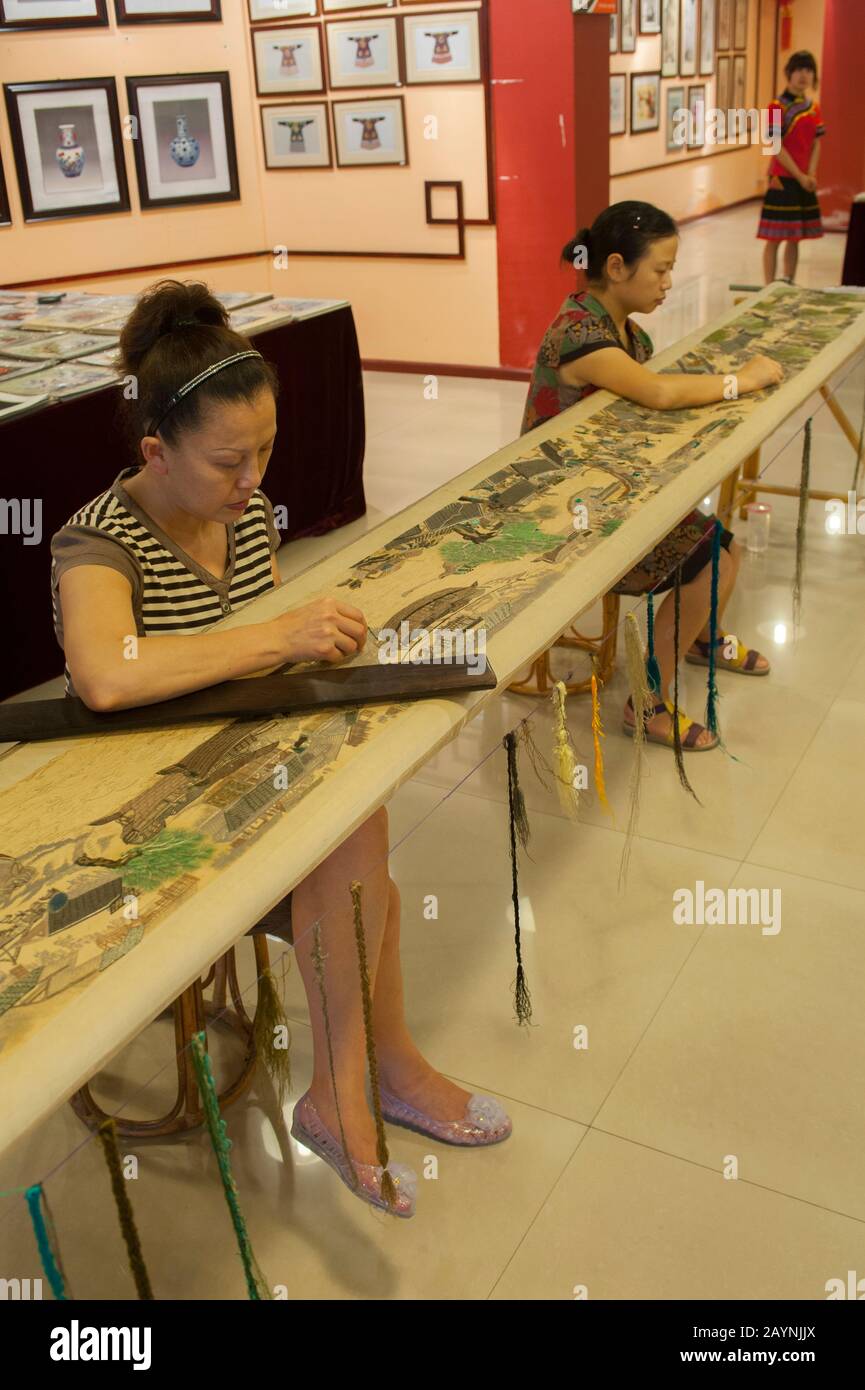 Frauen, die in einer Seidenstickerei in Yichang am Jangtsekiang in China arbeiten. Stockfoto