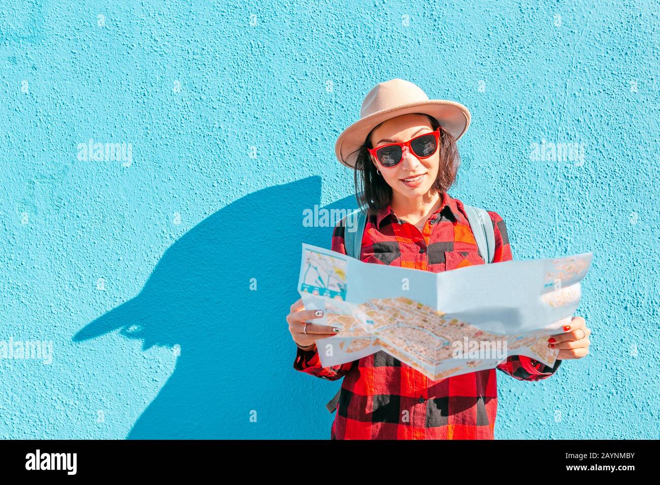 Ein junges, glückliches asiatisches Mädchen in einem Hut reist mit einer Karte in Burano, Venedig Stockfoto