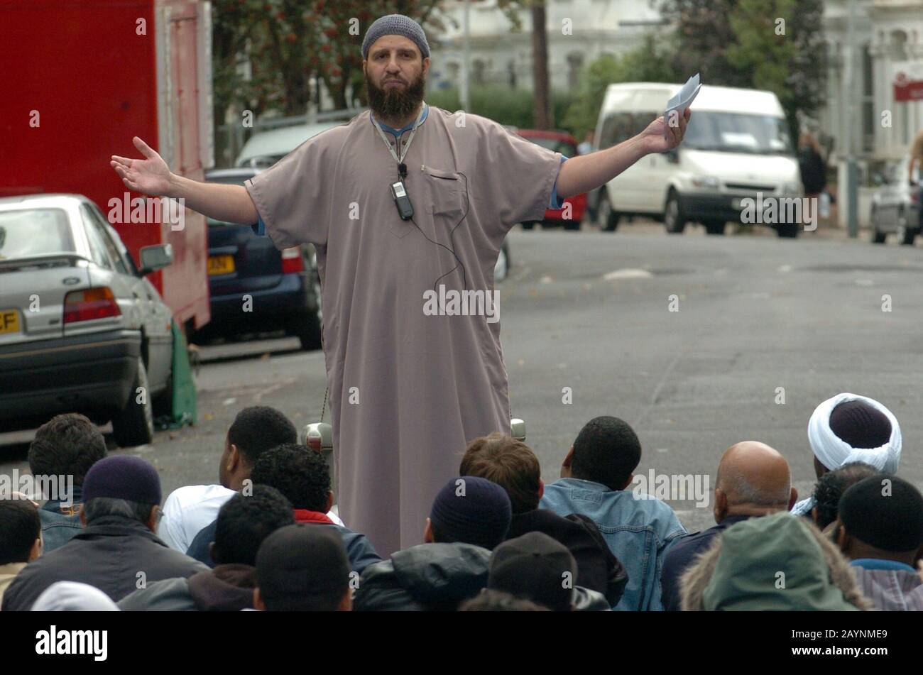 Atilla Ahmet alias abu abdullah ein Schüler von Abu Hamza führt Freitagsgebete auf der Straße vor einer Moschee im Finsbury Park, North London, nachdem sie auf bitten der Polizei geschlossen wurde, dass sie zu einem Treffpunkt für viele radikale Muslime geworden sei. Im Jahr 2003.150 Polizisten der Terrorismusbekämpfung führten einen nächtlichen überfall auf das Gebäude durch, indem sie eine Betäubungswaffe und einen Gasbehälter der CS beschlagten und sieben Männer nach dem Terrorismusgesetz 2000 feststellten. Der Inman Abu Hamza predigte bis zu seiner Verhaftung im Mai 2004 jeden Freitag auf der Straße vor der geschlossenen Moschee. Stockfoto