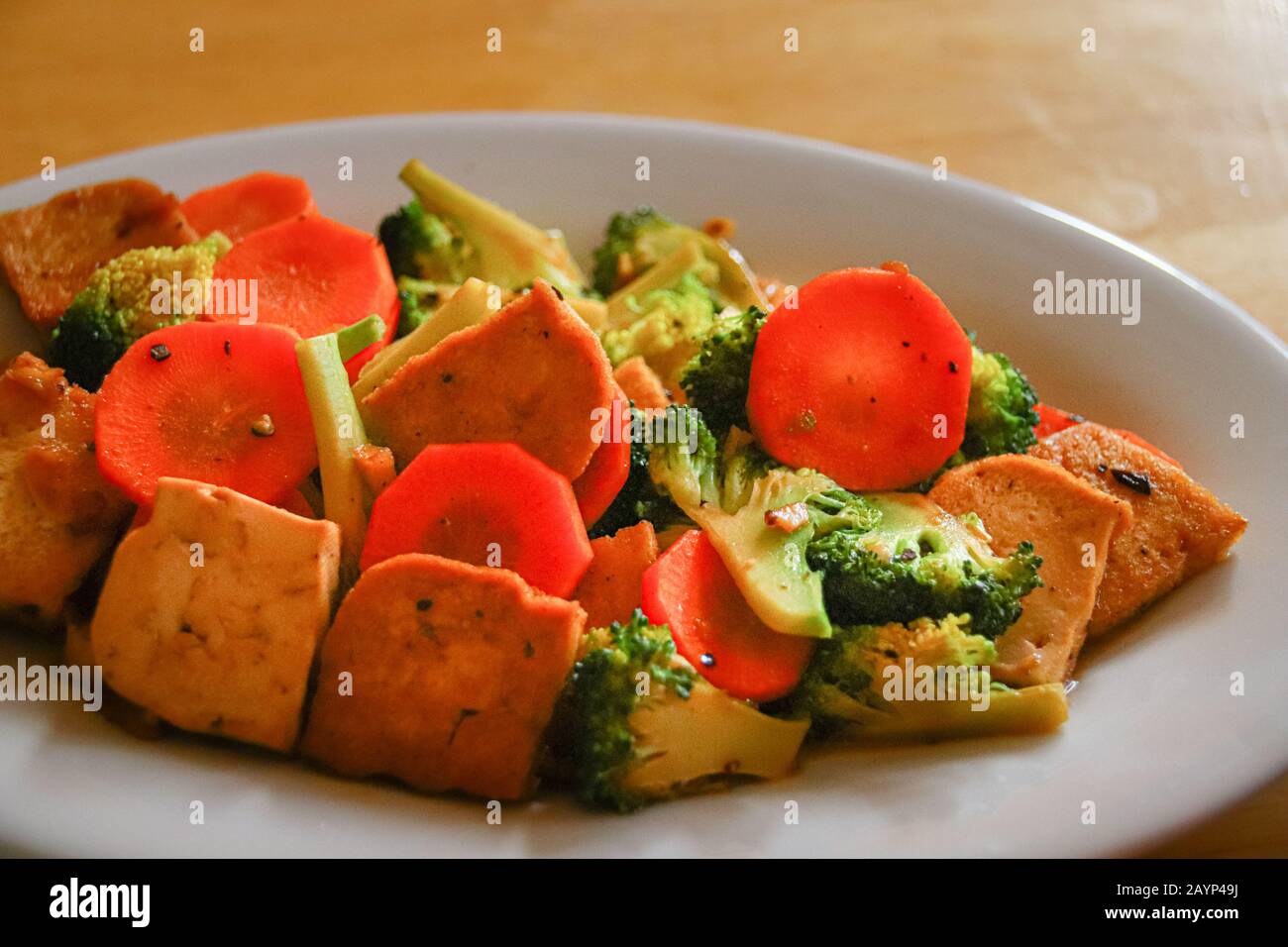 Rühren Sie gebratenen Tofu, Brokkoli und Karotten für ein gesundes veganes Mittagessen, um während der Quarantäne zu Hause gesund zu bleiben, da Covid-19 Pandemie Stockfoto