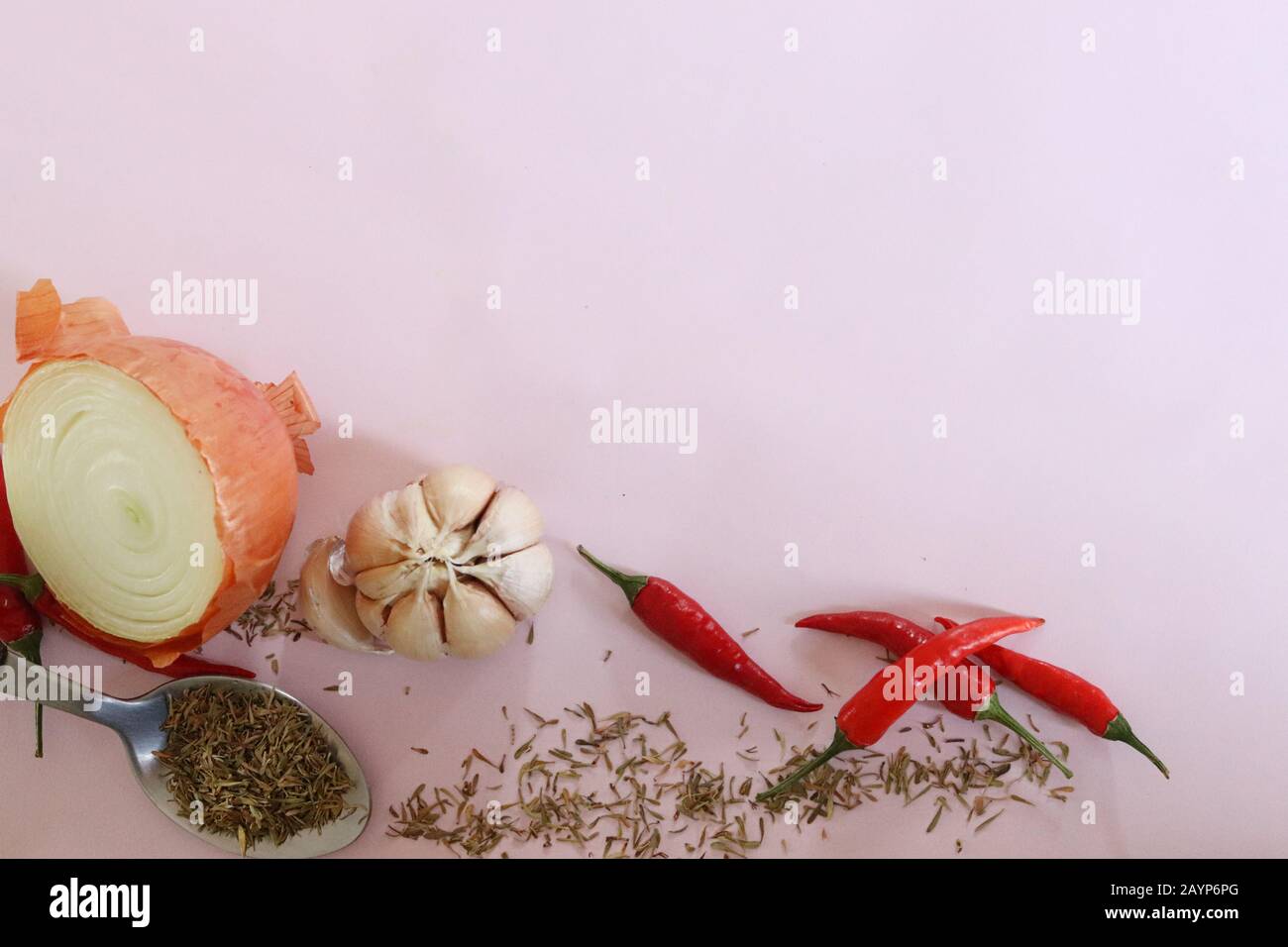 Gewürze und Kräuter zum Kochen vor einem rosafarbenen Hintergrund, um das Konzept von Gastronomie, Küche, Kochen und gesundem Leben zu zeigen Stockfoto