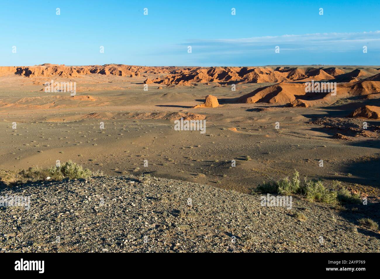 Sonnenschein am Abend auf den orangefarbenen Felsen von Bayan Zag, bekannt als Flaming Cliffs in der Wüste Gobi, der Mongolei, wo wichtige Dinosaurier-Fossilien zu finden sind Stockfoto