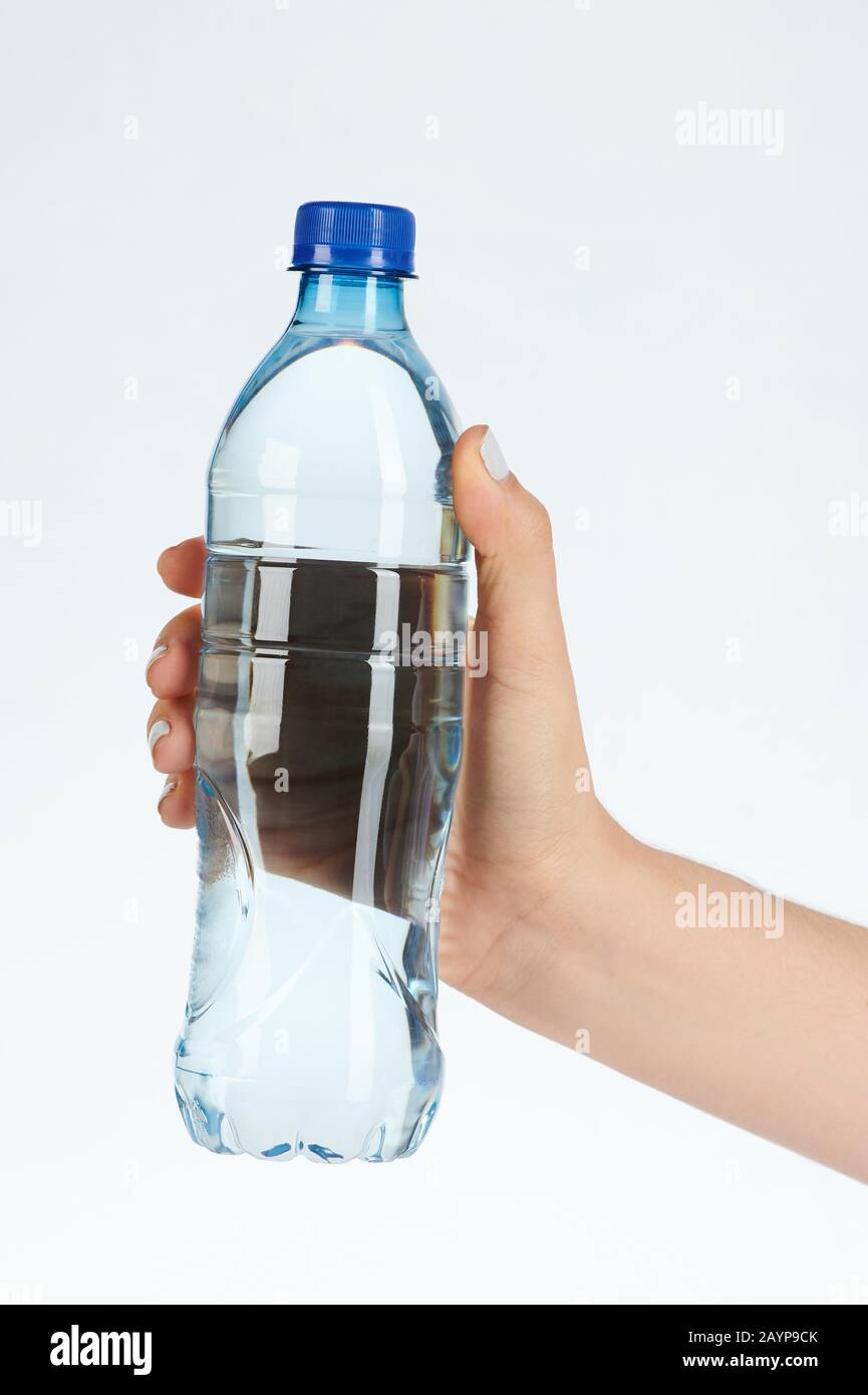 Frau hält durchsichtige Wasserflasche isoliert auf weißem Hintergrund Stockfoto