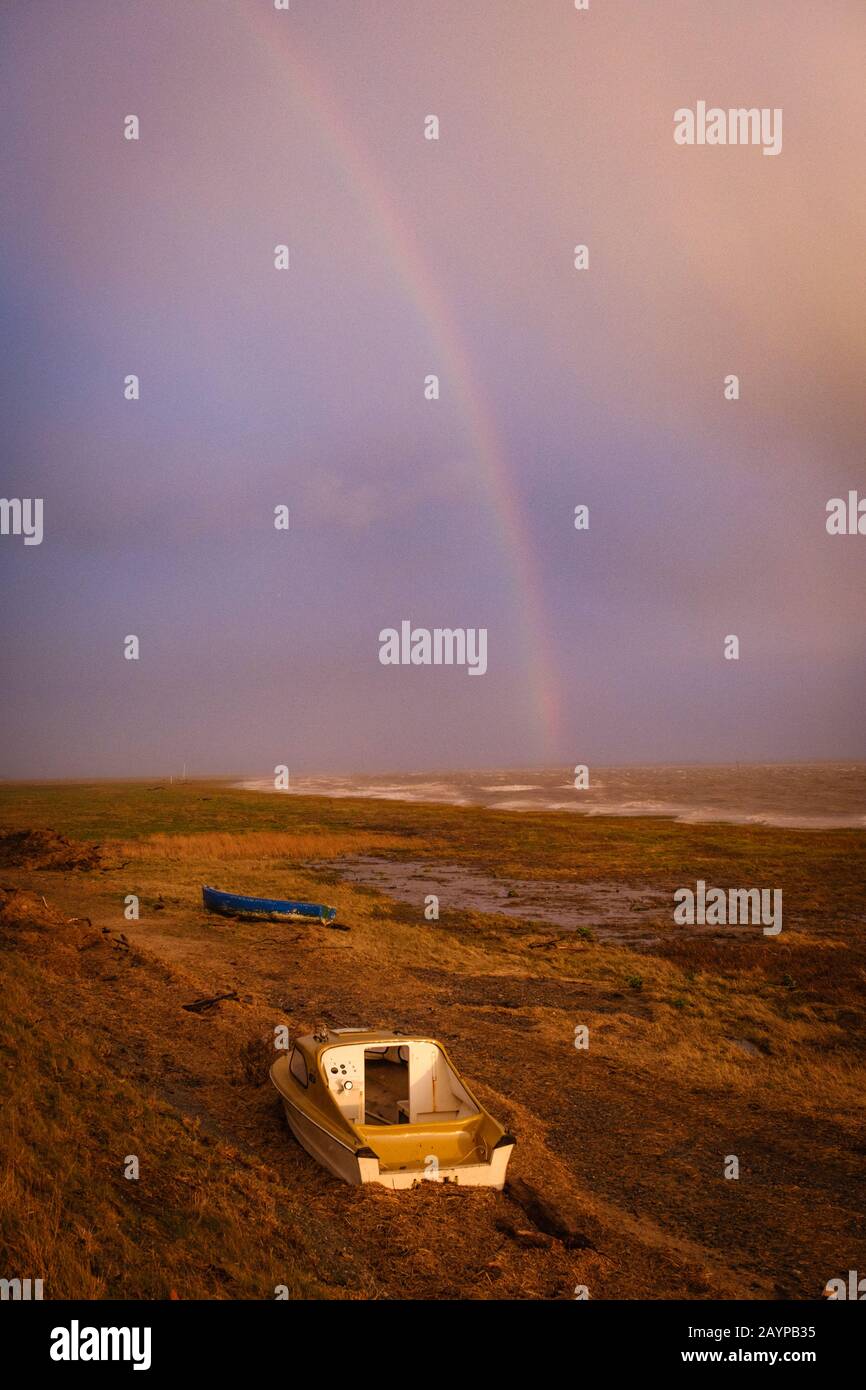 Ein Boot an der Seefront in Lytham mit einem Regenbogen an einem stürmischen Tag Stockfoto