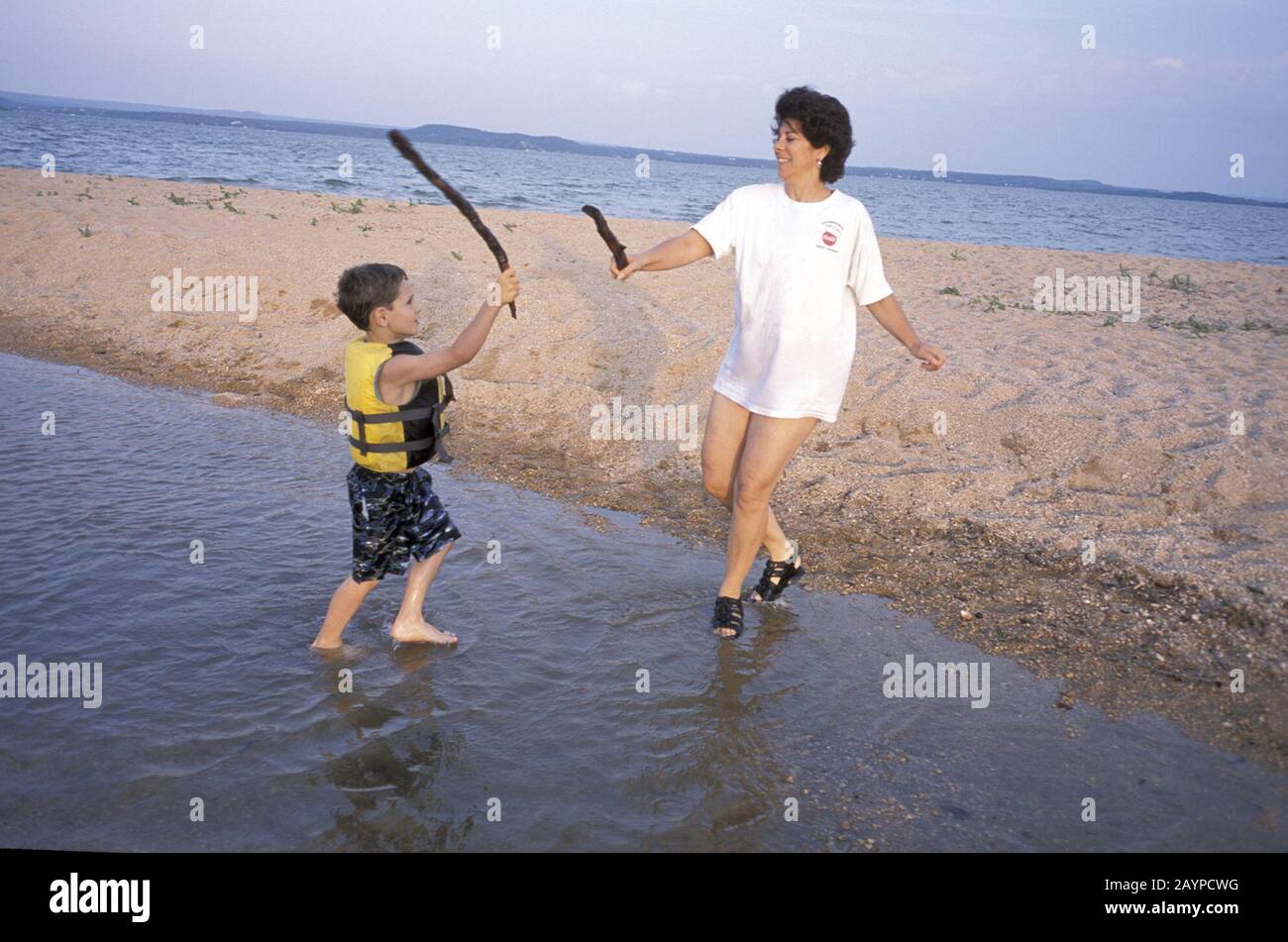 Mai 2003, Lake Buchanan, Texas: Mutter und Sohn, die sich am Strand als Schwertkampf ausgeben. ©Bob Daemmrich Stockfoto