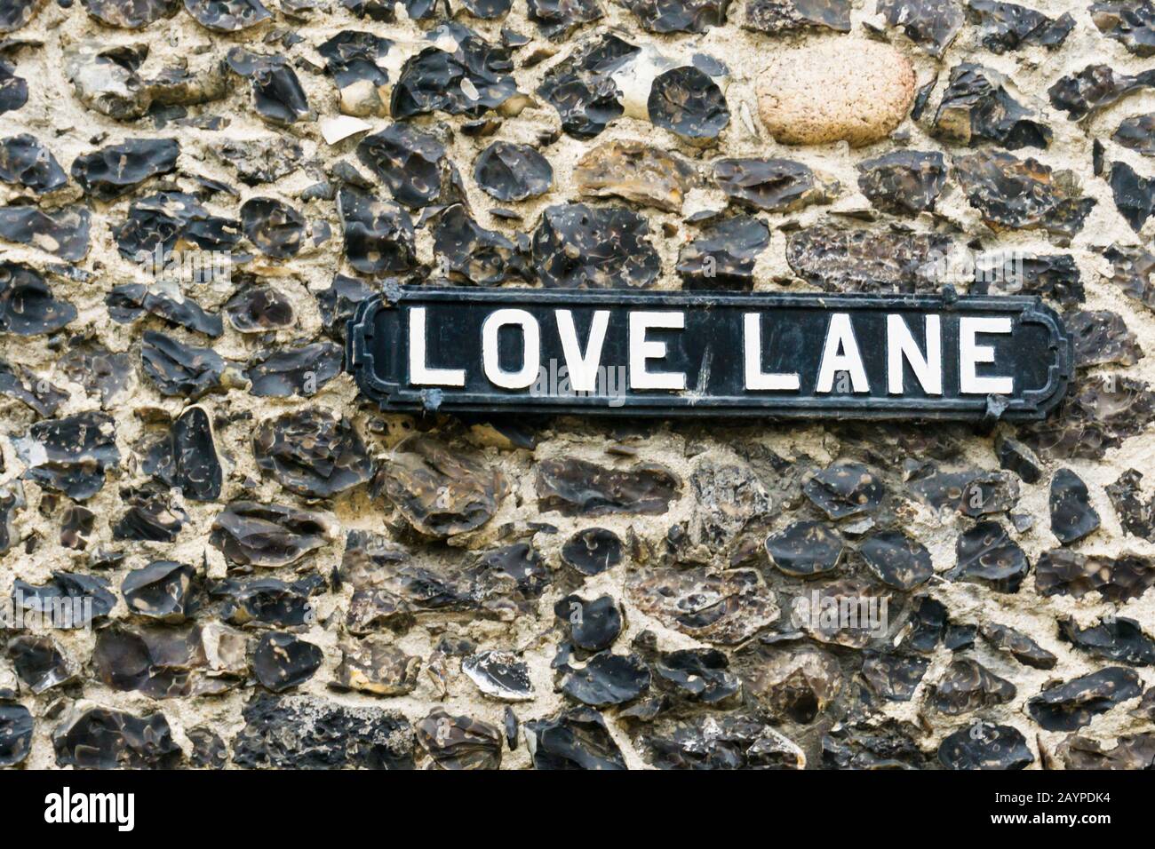 Ein altes Schild aus Metall für die Love Lane an einer Feuersteinwand in der Altstadt von Margate. Stockfoto