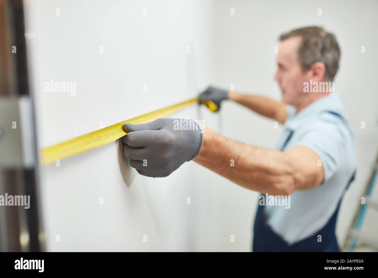 Nahaufnahmen von leitenden Bauarbeitern, die die Wand messen, während sie das Haus renovieren, kopieren Sie den Raum Stockfoto