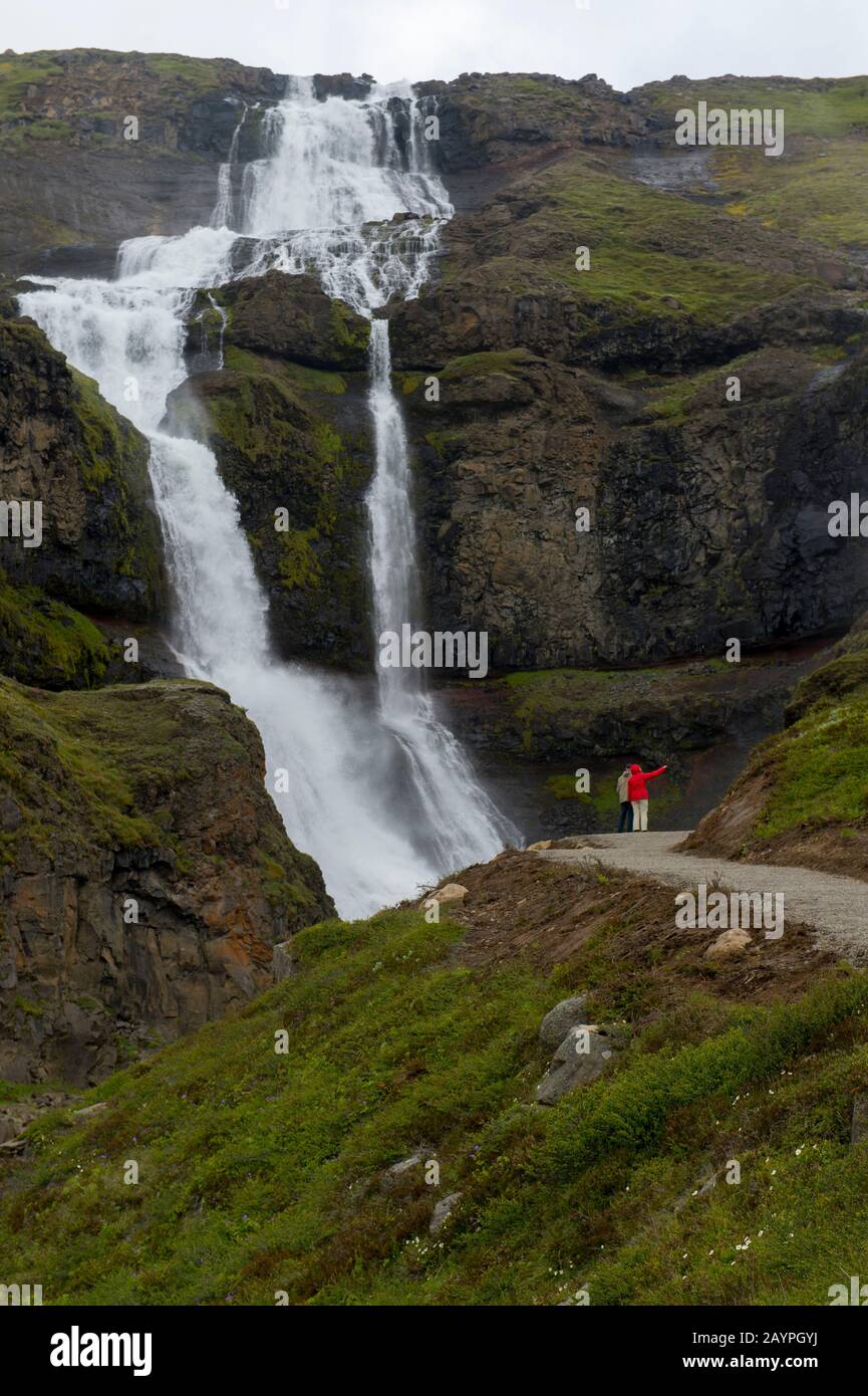 Menschen an einem Wasserfall in der Nähe von Hofteigur im Nordosten Islands. Stockfoto