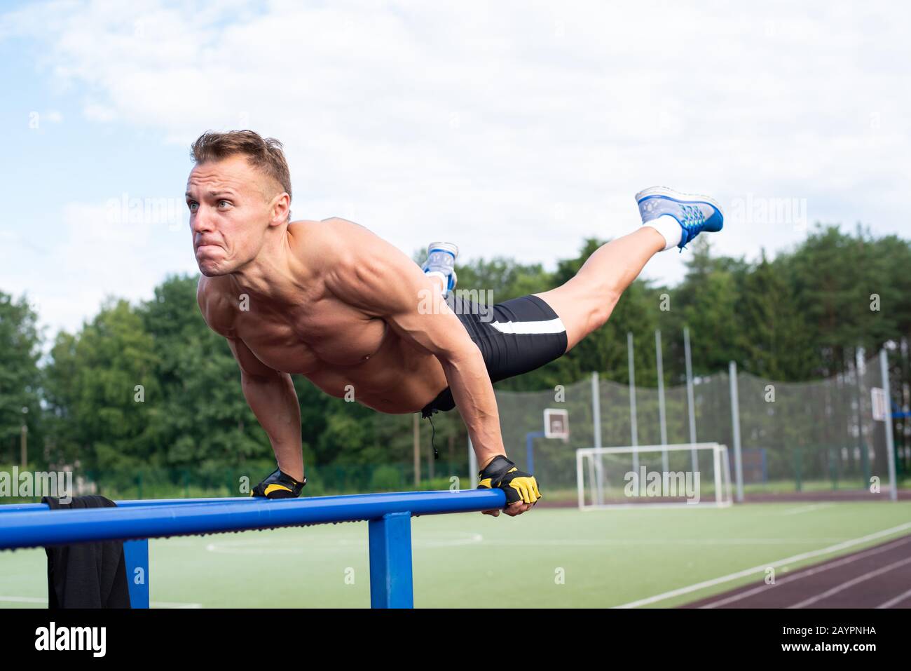 Ein muskulöser Mann wird aus parallelen Stäben ausgewrungen. Stockfoto