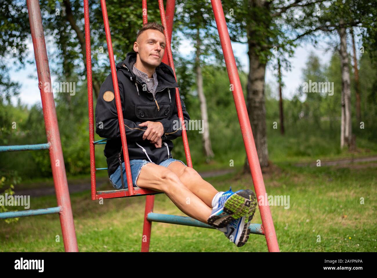 Ein Mann auf Babyschaukeln und Karussells. Stockfoto
