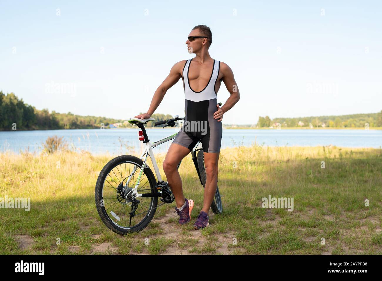 Ein Mann mit einem Fahrrad in der Natur, auf einem Feld. Stockfoto