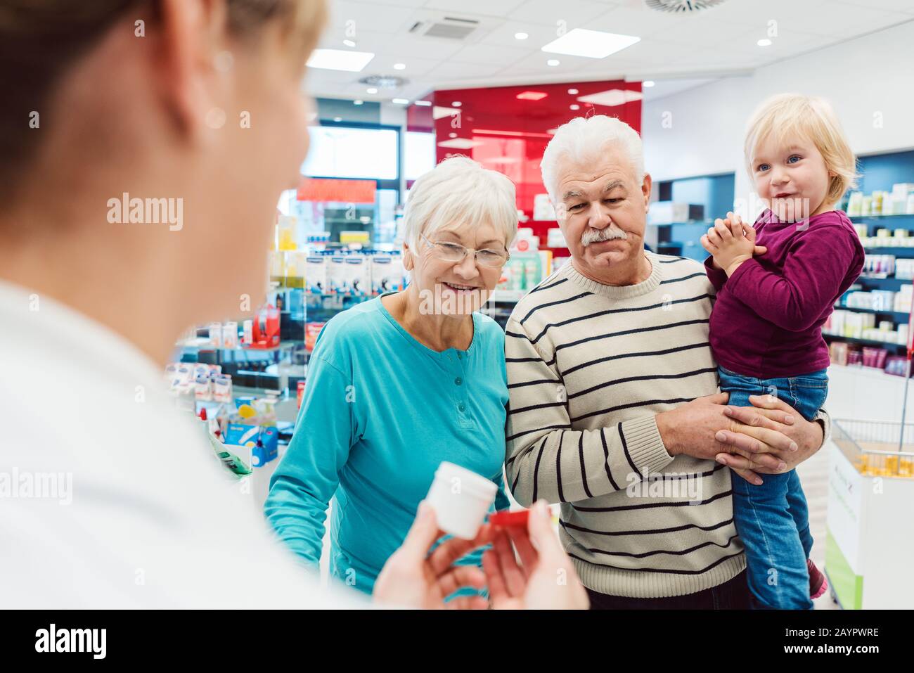 Großeltern in der Apotheke kaufen verschreibungspflichtige Medikamente für Enkel Stockfoto