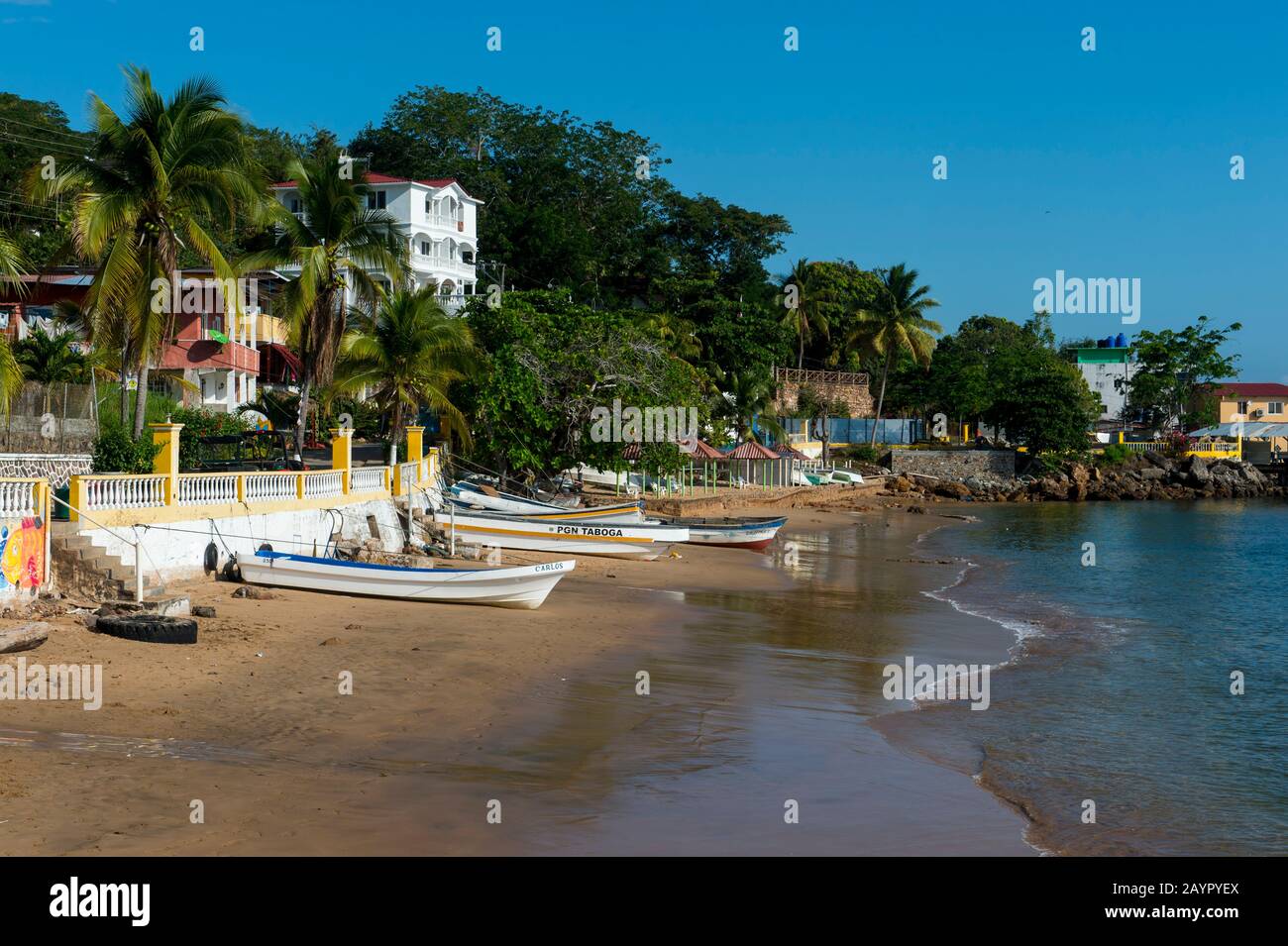 Blick auf den Strand mit Fischerbooten vor dem Dorf der tropischen Insel Isla Taboga vor der Küste von Panama-Stadt, Panama. Stockfoto