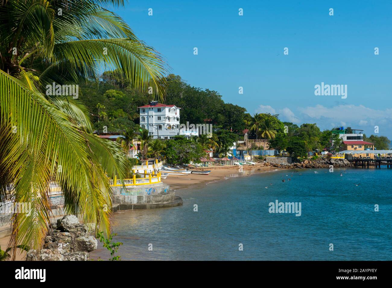 Blick auf den Strand mit Fischerbooten vor dem Dorf der tropischen Insel Isla Taboga vor der Küste von Panama-Stadt, Panama. Stockfoto