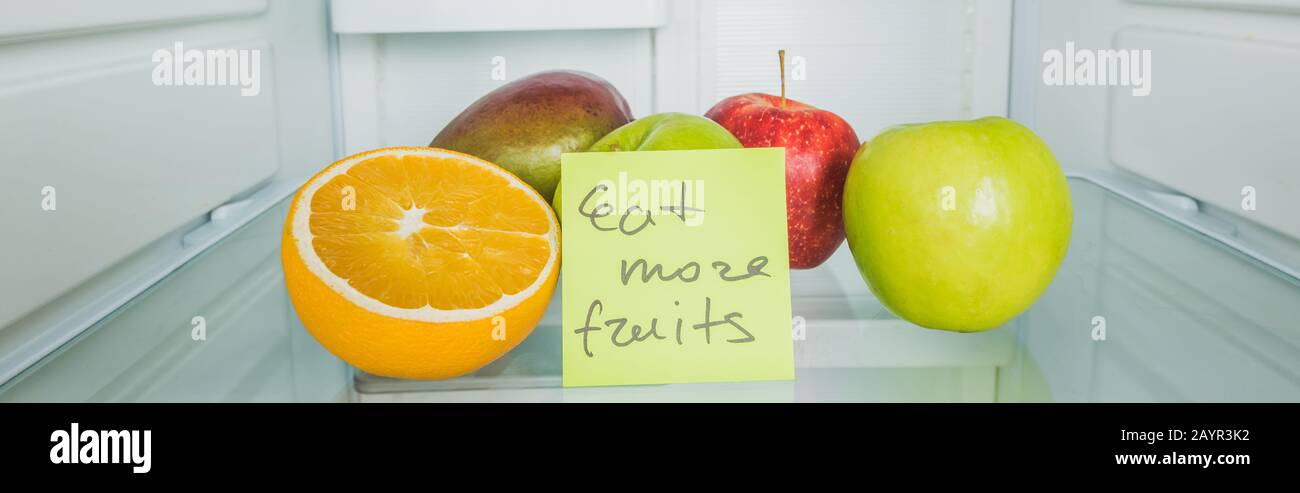 Panoramaaufnahme von frischen Früchten und Karre mit Eat More Fruchts-Schriftzug auf Kühlschrankregal, Stock-Bild Stockfoto