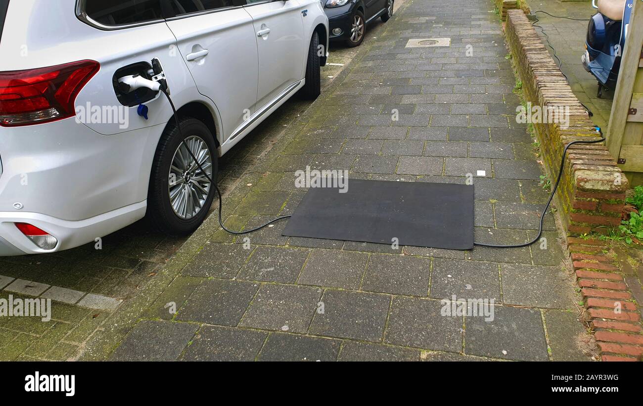 Ladekabel für ein E-Auto, das auf dem Gehweg liegt, eine Matte, die ein Stolpern verhindert, Niederlande Stockfoto