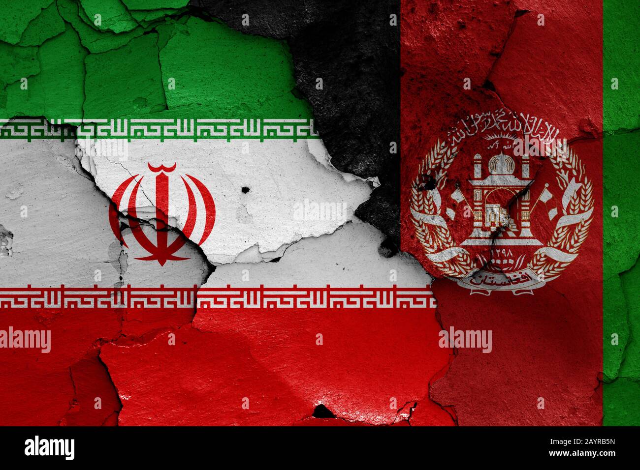Flaggen des Iran und Afghanistans auf gerissene Wand gemalt Stockfoto