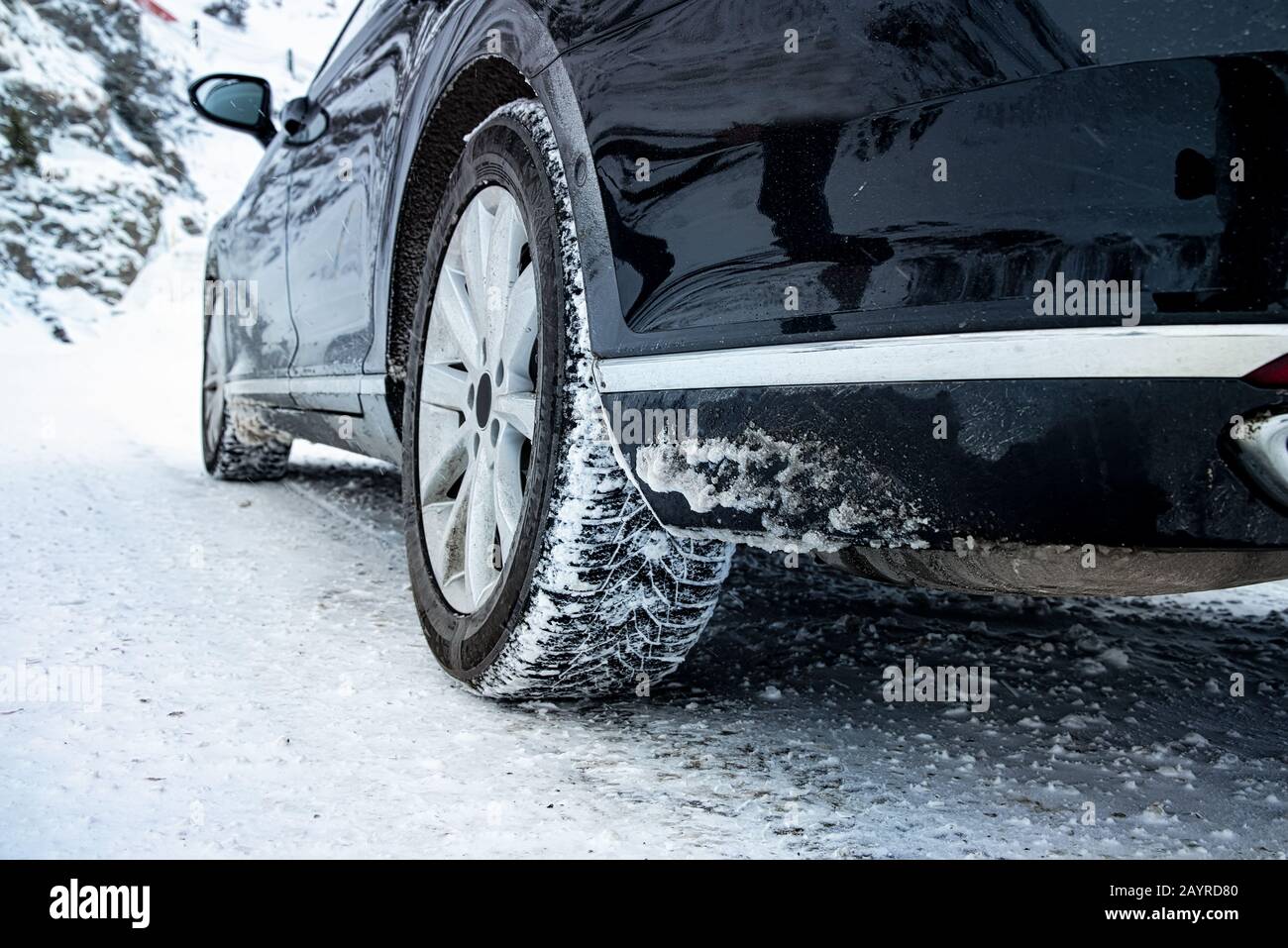Nahaufnahme von PKW-Reifen im Winter auf der Straße mit Schnee bedeckt Stockfoto